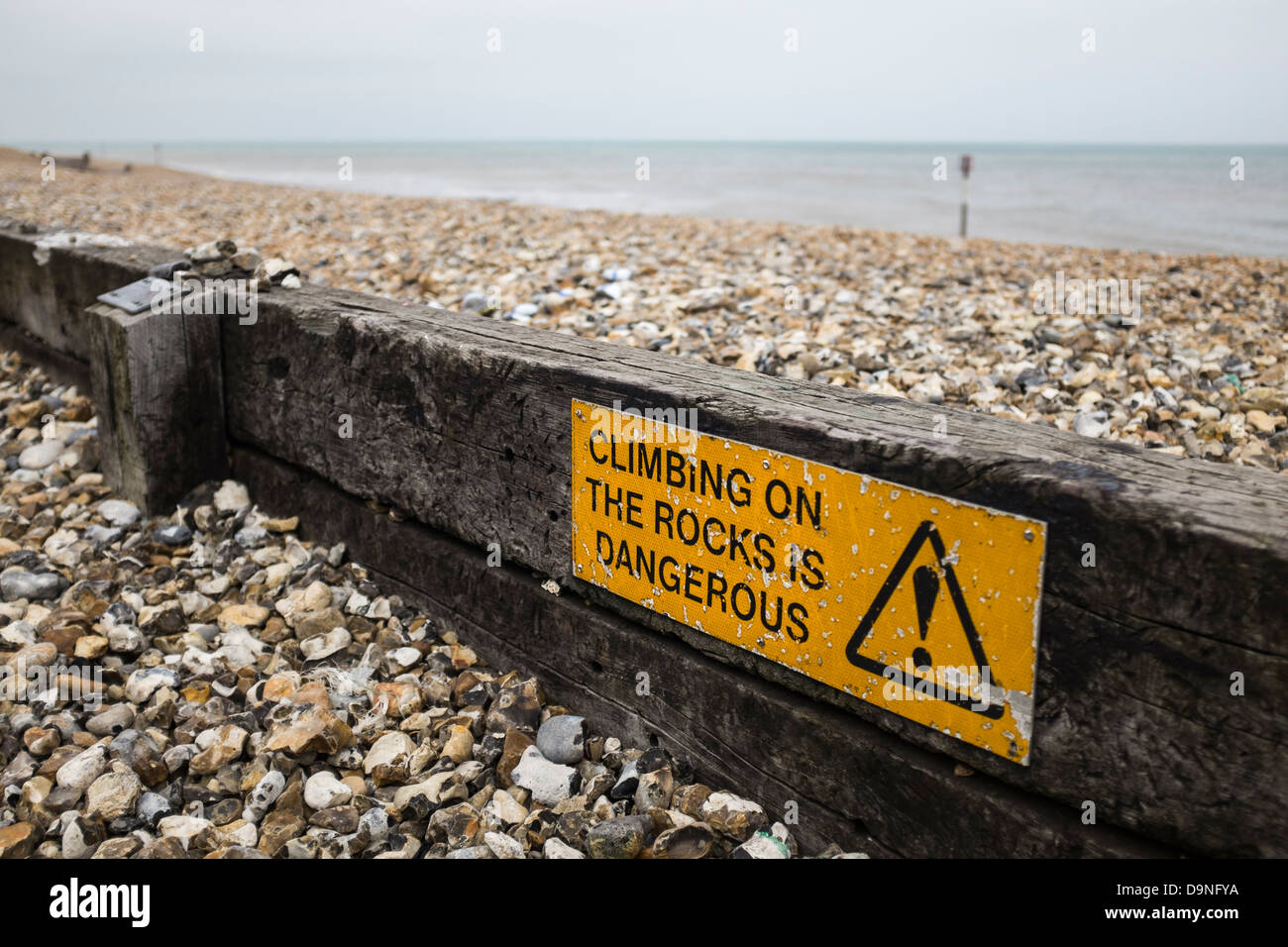 Segnale di avvertimento su una spiaggia 'arrampicata sulle rocce è pericoloso". Foto Stock