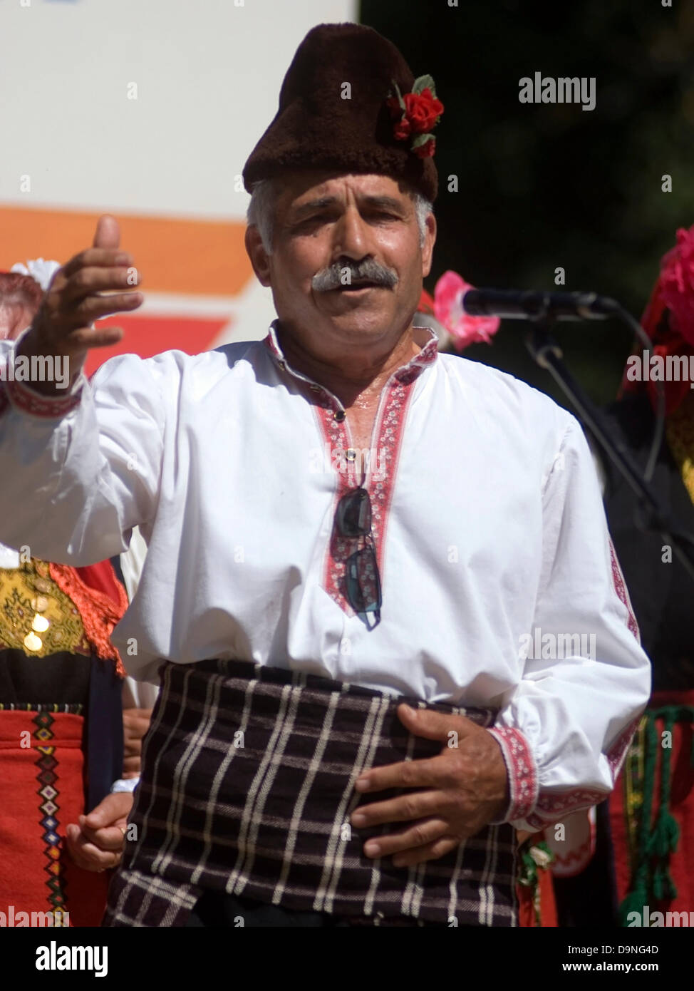 Uomini donne bambini vestiti nei tradizionali costumi nazionali singing competition intrattenere i visitatori e viaggiatori, Bulgaria Foto Stock