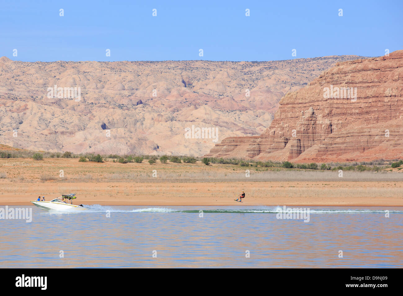 Un acqua sciatore è trainata posteriormente ad una imbarcazione in Bullfrog Bay presso il lago Powell, Utah Foto Stock