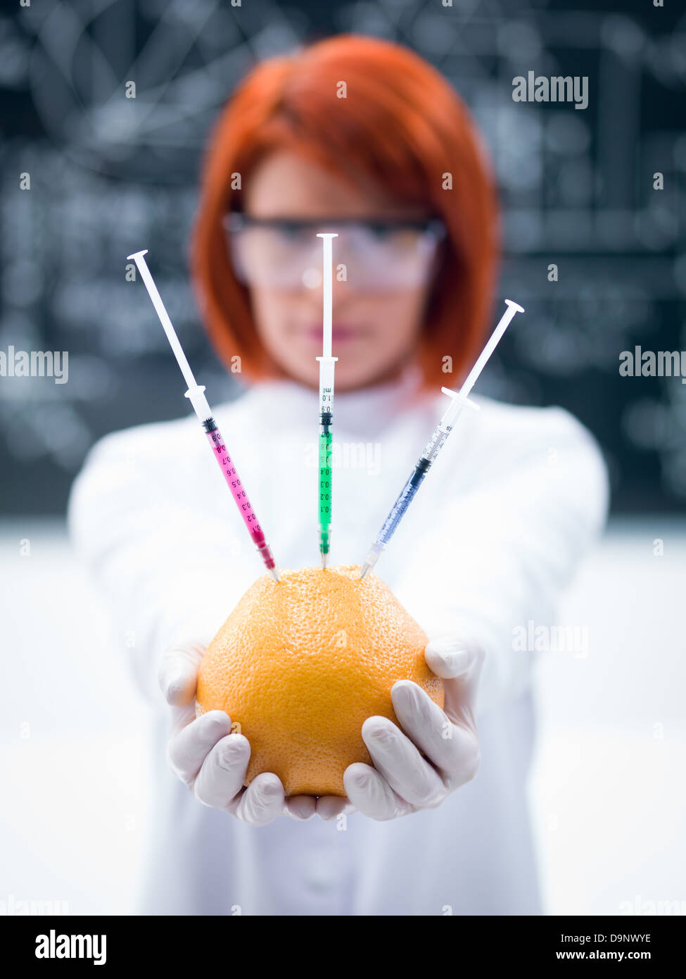 Macro di un palmare di pompelmo iniettato da una donna in un laboratorio di chimica Foto Stock