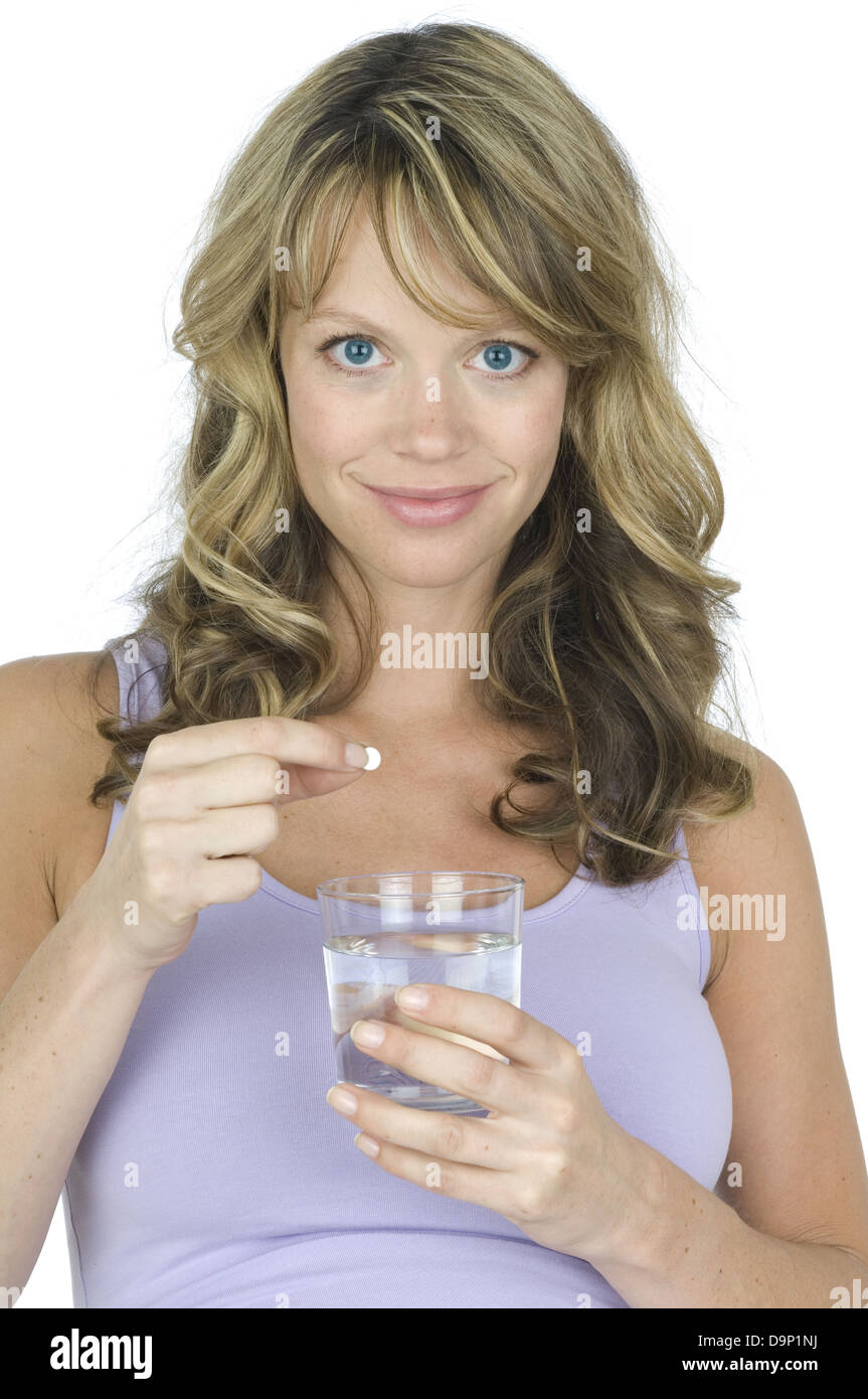 Donna prendendo la pillola con un bicchiere di acqua Foto Stock