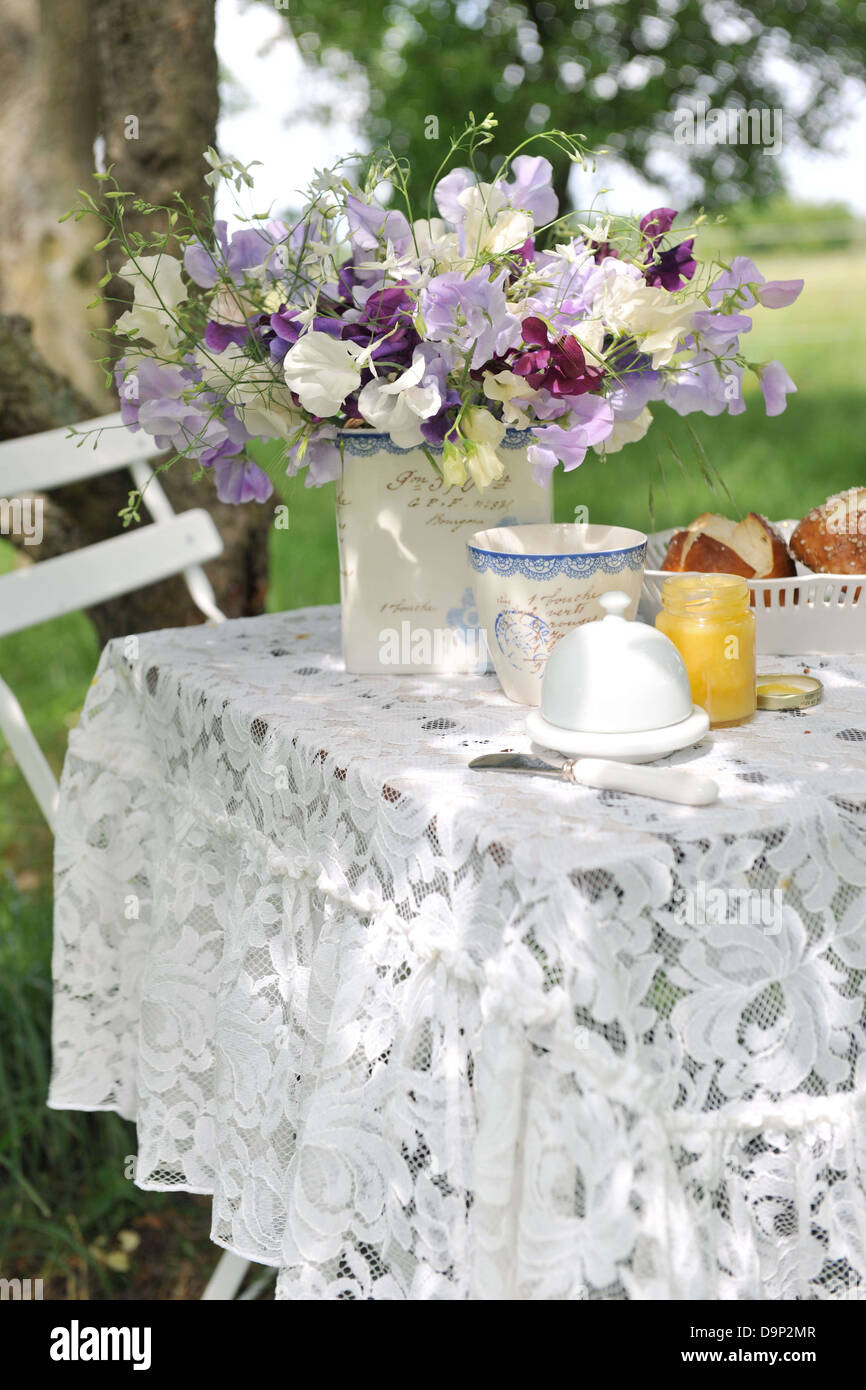 Fiori, miele e lye rotola sul tavolo da giardino Foto Stock