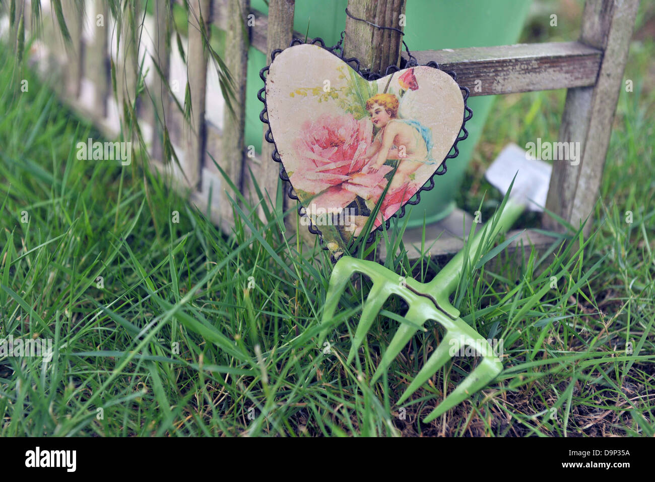 Cuore decorativo e utensile da giardinaggio in erba Foto Stock