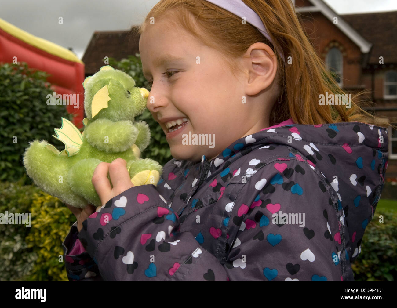 6 anno vecchia ragazza con un fatti a mano green dragon a un orsacchiotto di peluche festival, Alton, HAMPSHIRE, Regno Unito. Foto Stock