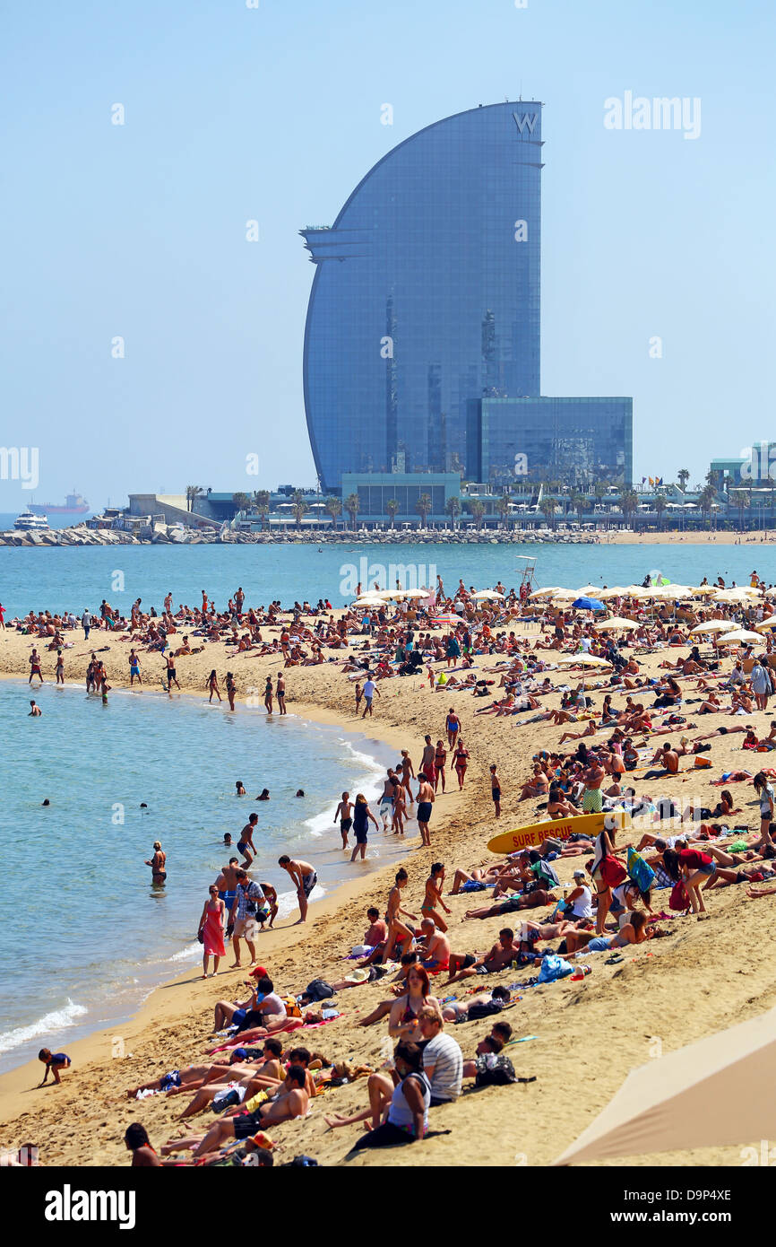 Scena della folla vacanze sulla spiaggia affollata e il W Hotel, Barcelona, Spagna Foto Stock