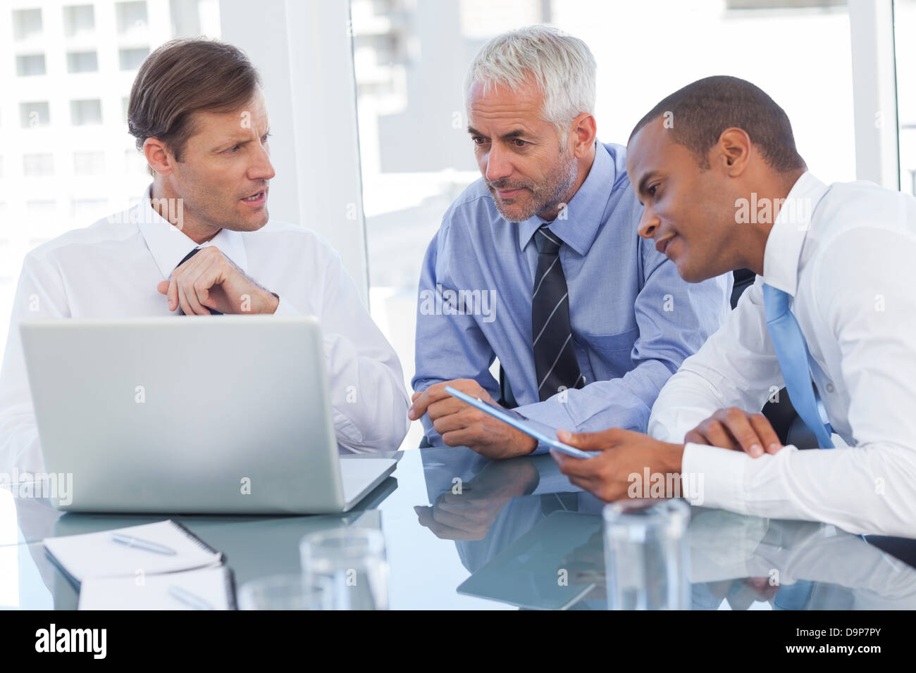 Tre uomini di affari la visione di un laptop Foto Stock