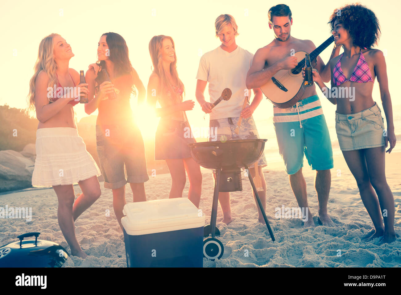 Amici per la cottura barbecue sulla spiaggia Foto Stock