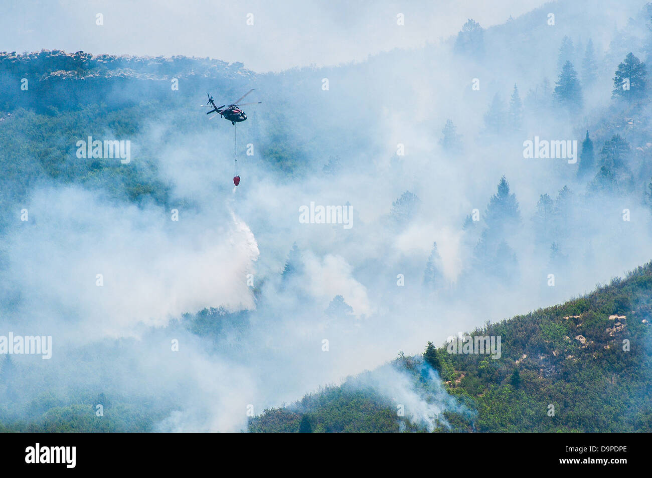 US Army UH-60 Black Hawk elicotteri trasportano bambi secchielli riempiti con acqua per contribuire a contenere il picco est Fire wildfire Giugno 21, 2013 vicino La Veta, CO. Il fuoco ha cominciato dopo un alleggerimento sciopero ha bruciato 13.000 acri di foresta. Foto Stock