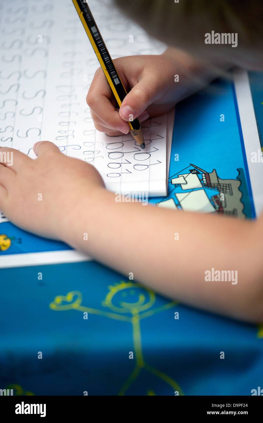 Close up di un Regno Unito la scuola primaria bambino facendo pratica della scrittura. Foto Stock