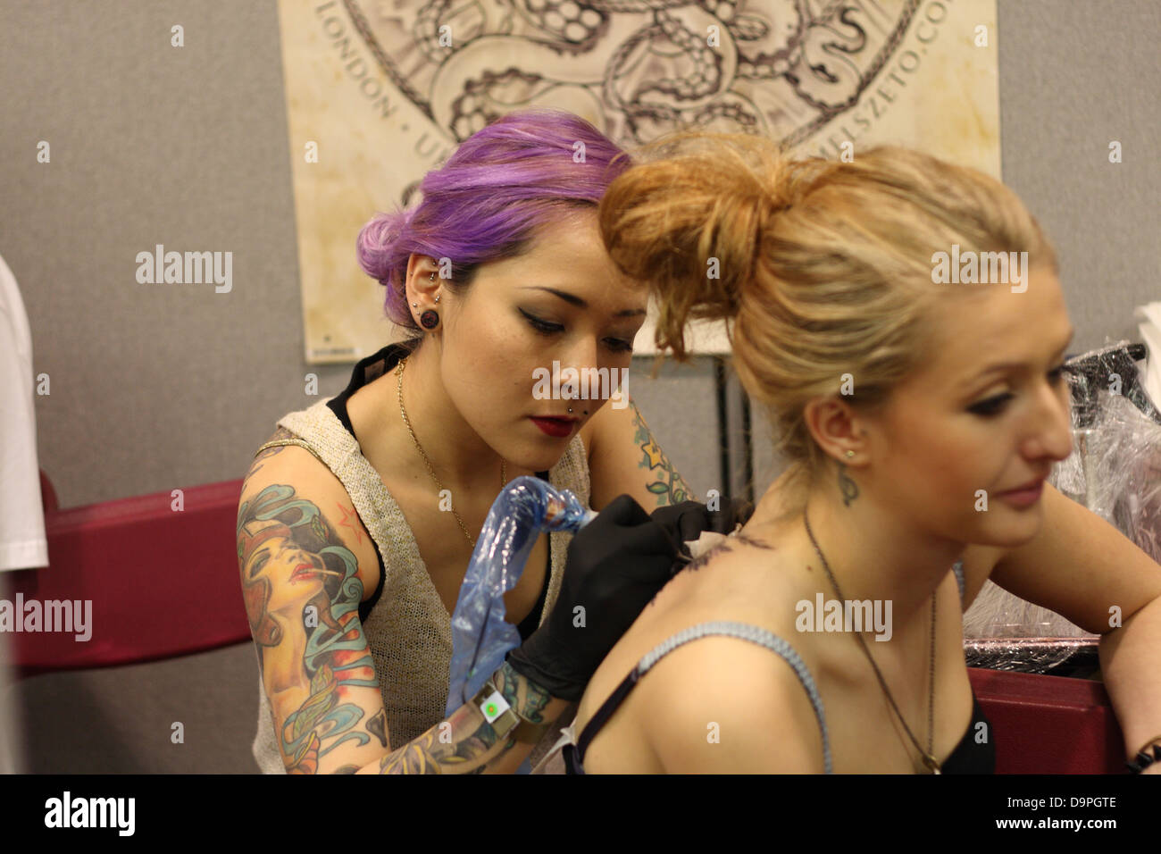 Tattooist funzionante a Brighton tattoo convention Foto Stock