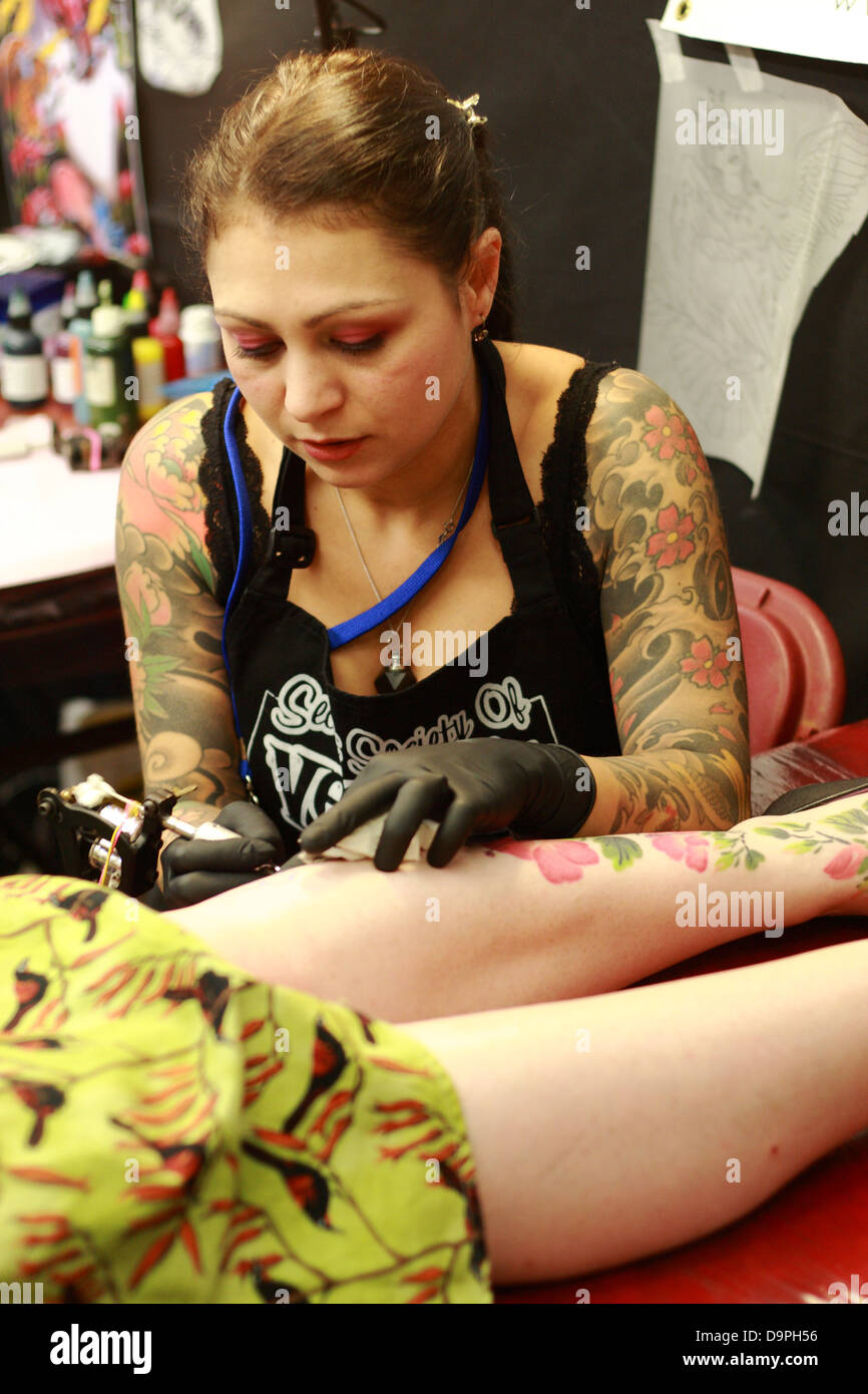Tattooist femmina funzionante a Brighton tattoo convention Foto Stock