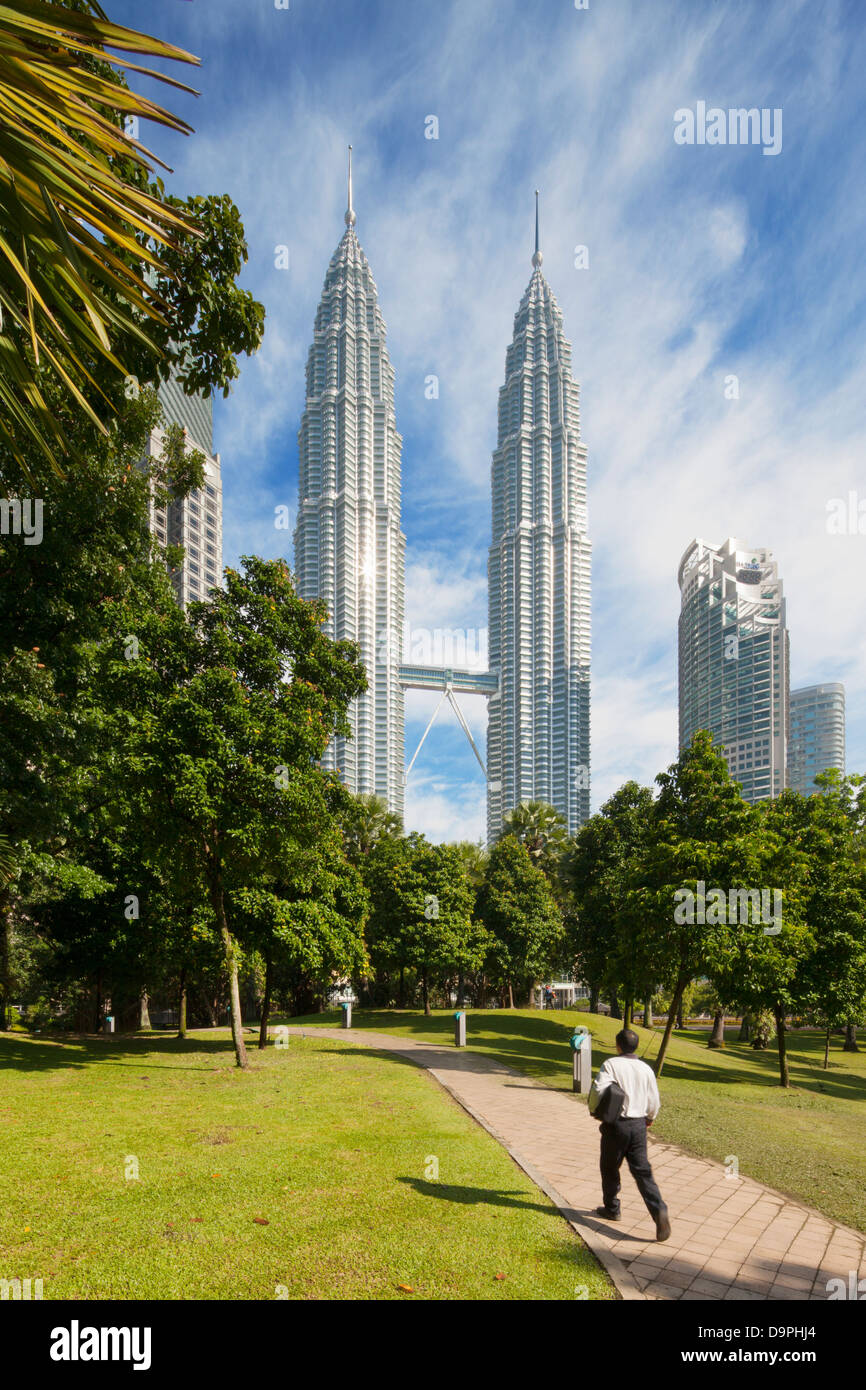 Un uomo a piedi attraverso il lavoro del Parco KLCC Petronas Twin Towers, Kuala Lumpur, Malesia Foto Stock
