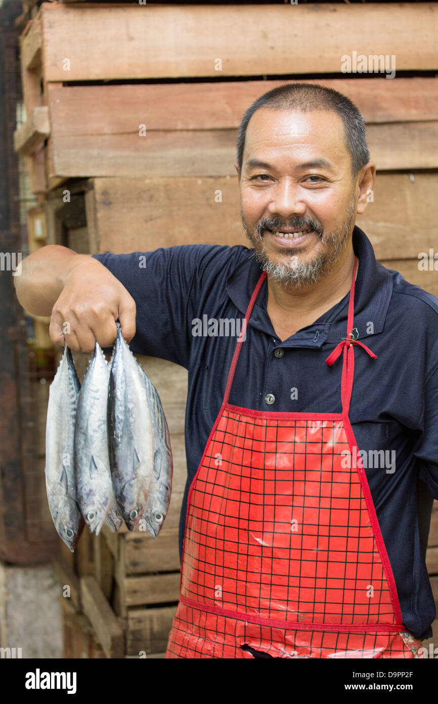 Fish monger tenendo il pesce, del Mercato Centrale, Kota Bharu, Kelantan, Malaysia Foto Stock