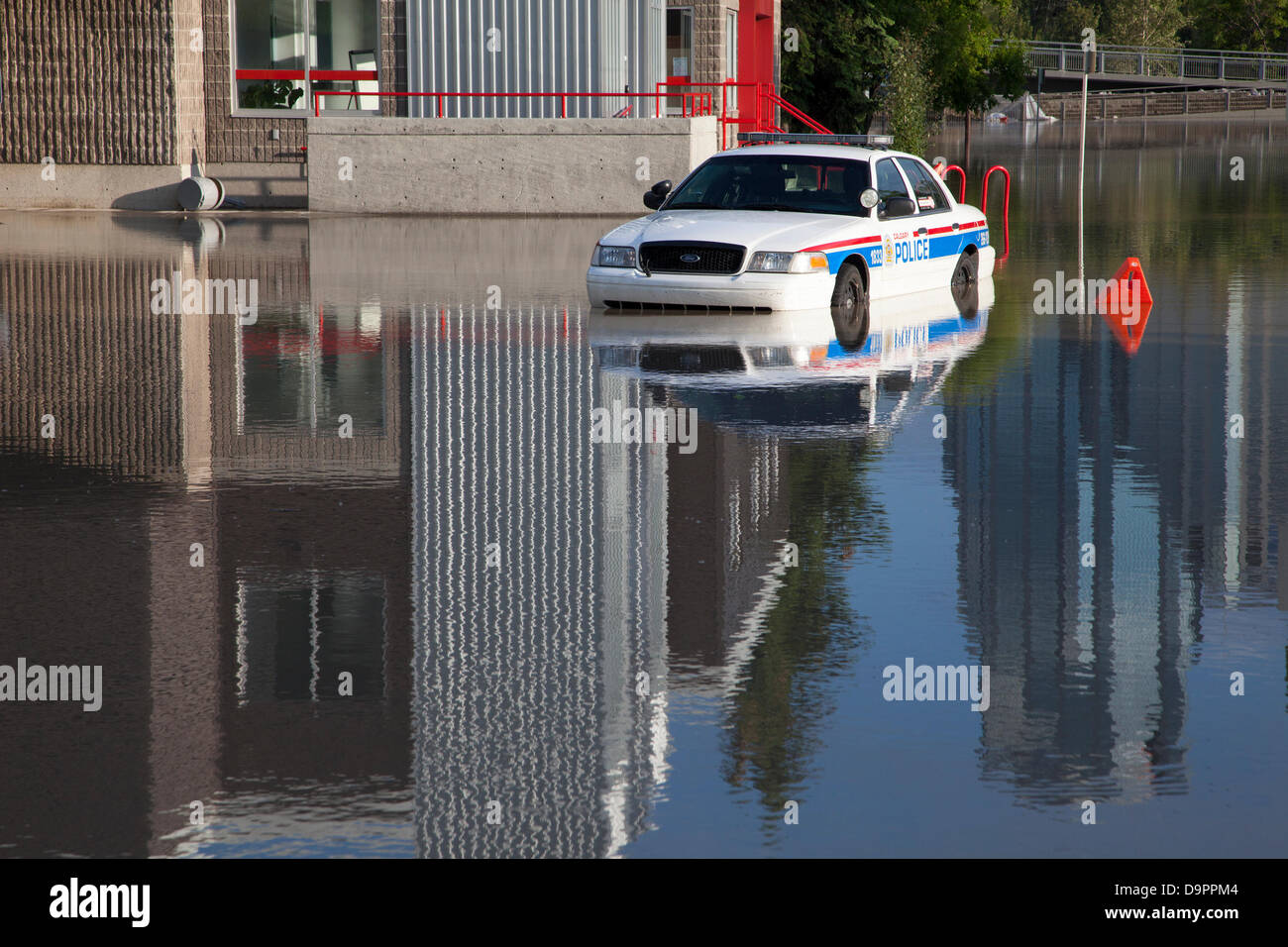 Un'auto della polizia intrappolata in un parcheggio da acque alluvionali in rapido aumento mentre la polizia evacuò il quartiere Sunnyside di Calgary, Alberta, Canada. Foto Stock