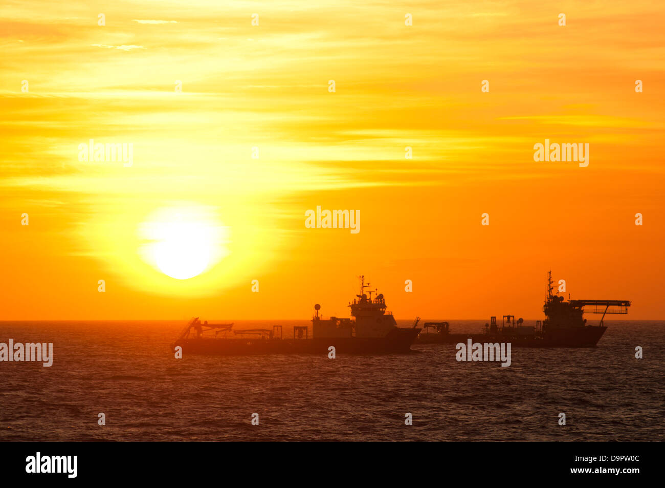 Silhouette di navi da rifornimento fluttuanti a Campos Basin, Rio de Janeiro, l'orario del tramonto. Foto Stock