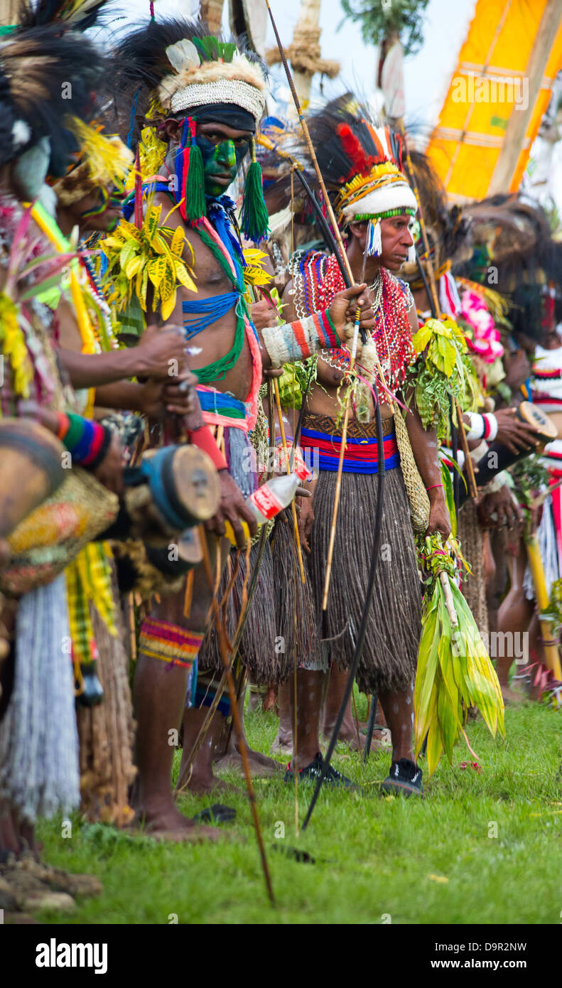 Persone vestite nei tradizionali abiti tribali e portando bandiere tribali a Goroka show nelle Highlands di Papua Nuova Guinea Foto Stock
