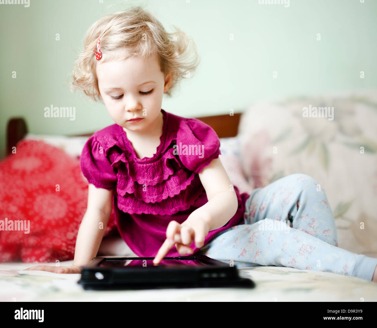 Carino bambina utilizzando computer tablet Foto Stock