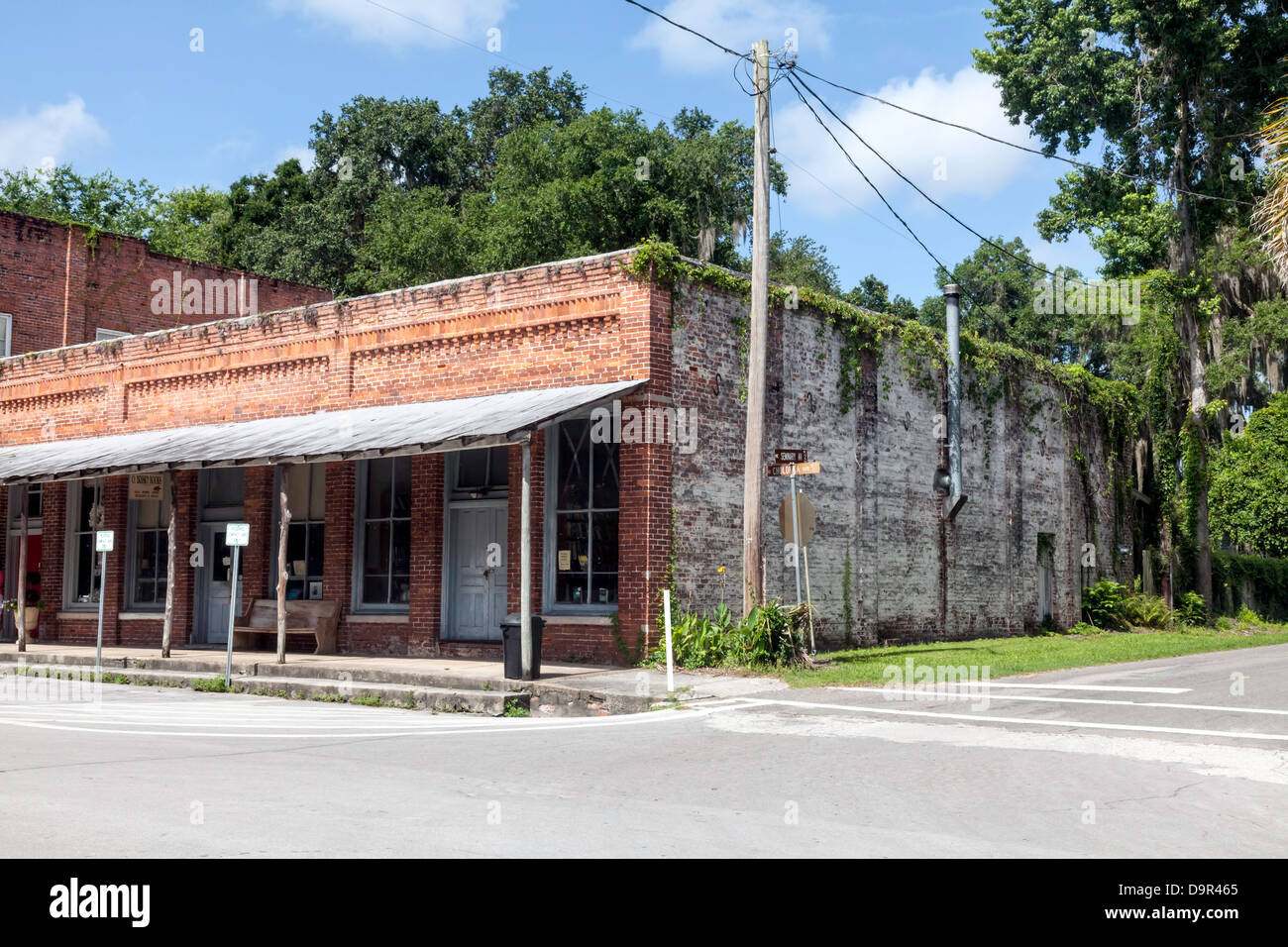Vecchio single-storia mattone edificio commerciale con portico che copre il marciapiede situato nel quartiere storico di Micanopy, Florida. Foto Stock