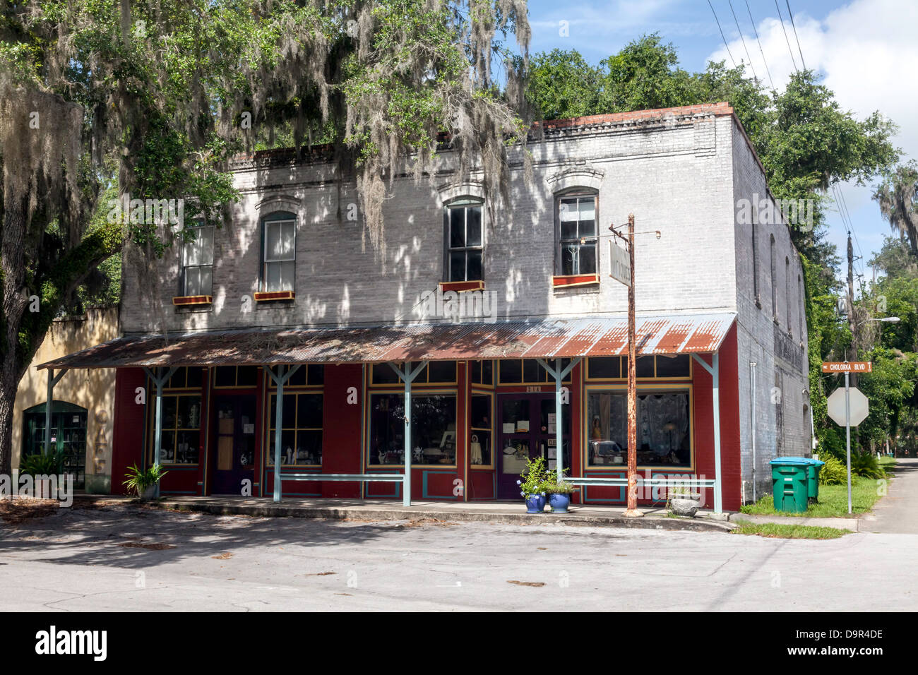 Il vecchio negozio di antiquariato in un 2-storia commerciale edificio in mattoni con marciapiede coperto nel quartiere storico di Micanopy, Florida. Foto Stock