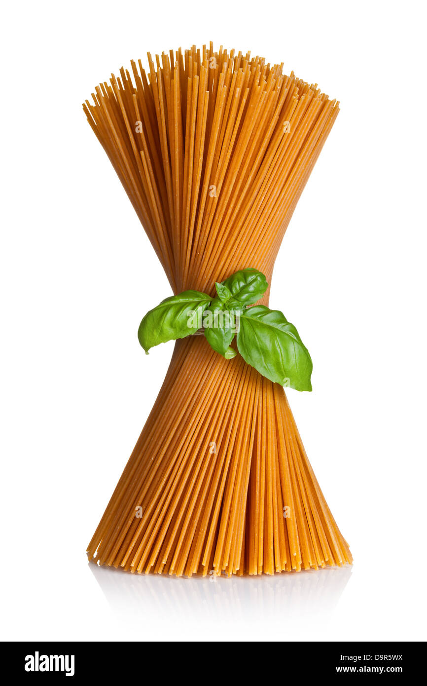 Spaghetti con basilico isolati su sfondo bianco. Mazzetto di tutta la pasta di grano Foto Stock