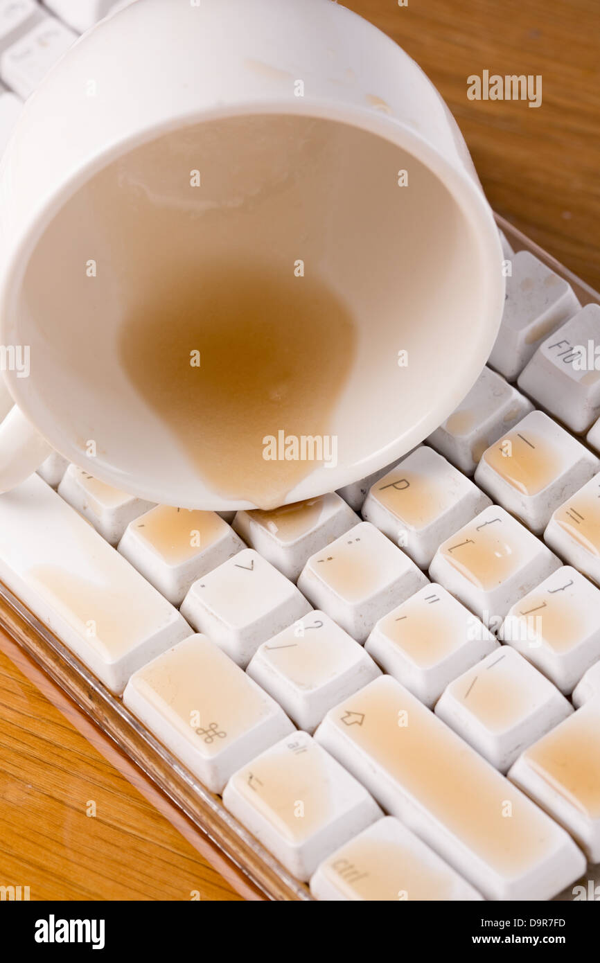 Tazza di tè rovesciato sopra una tastiera vicino fino Foto Stock