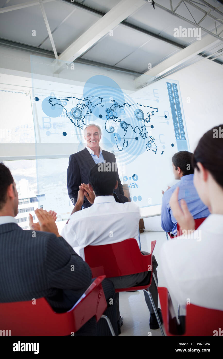 La gente di affari battimani stakeholder in piedi di fronte a mappa interfaccia schema Foto Stock