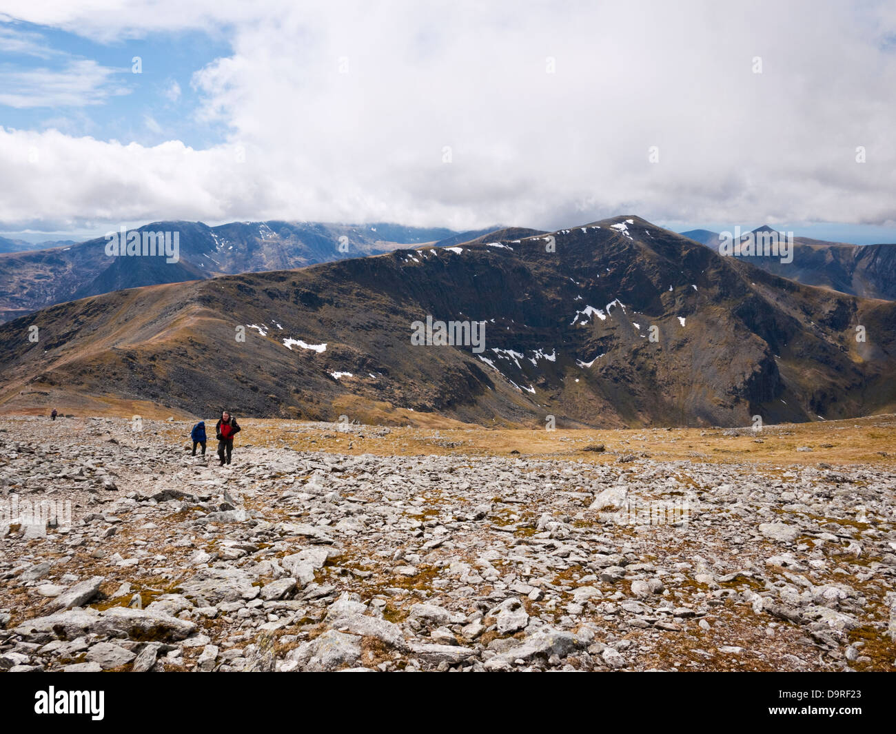 Hill walkers ascend Carnedd Llewelyn con Dafydd Carnedd fornendo lo sfondo di montagne Carneddau, Snowdonia. Foto Stock