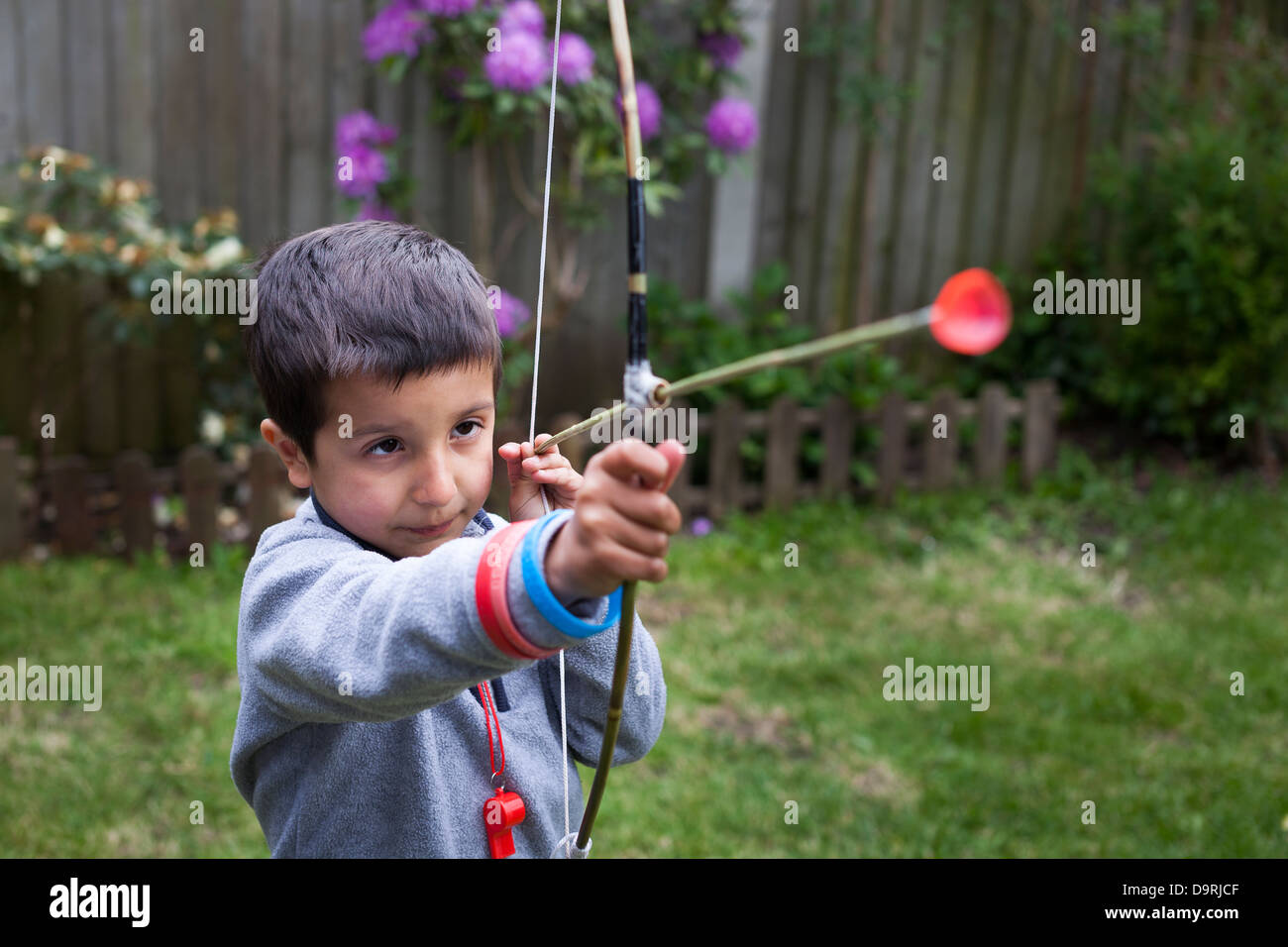 Ragazzo giovane mira con fatti in casa a base di arco e frecce Foto Stock