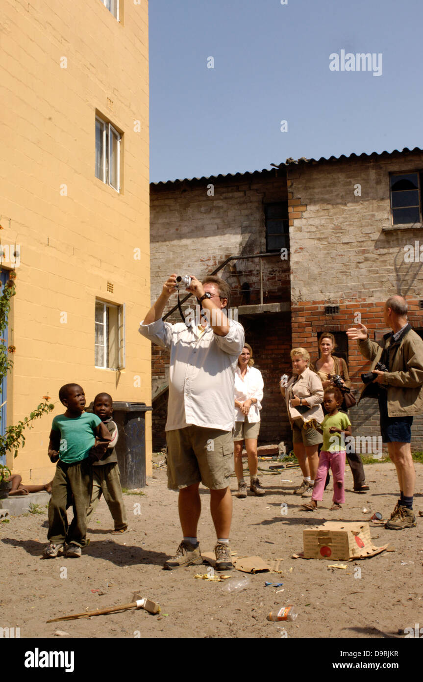 Township turisti visitano Langda district costruito durante l'apartheid del tardo 40's primi anni cinquanta a casa africano nero e colorato i lavoratori oggi le case sono spesso sovraffollate con come molti come 13 membri per nucleo familiare occuping due o tre camere e la condivisione di strutture con altre famiglie - La città è attualmente rimessa a nuovo e rebuiding in questa zona di Città del Capo Sud Africa scene e persone foto e copyright nick cunard la commissione indipendente "Review Magazine' 24sept-01Ott 2006 Foto Stock