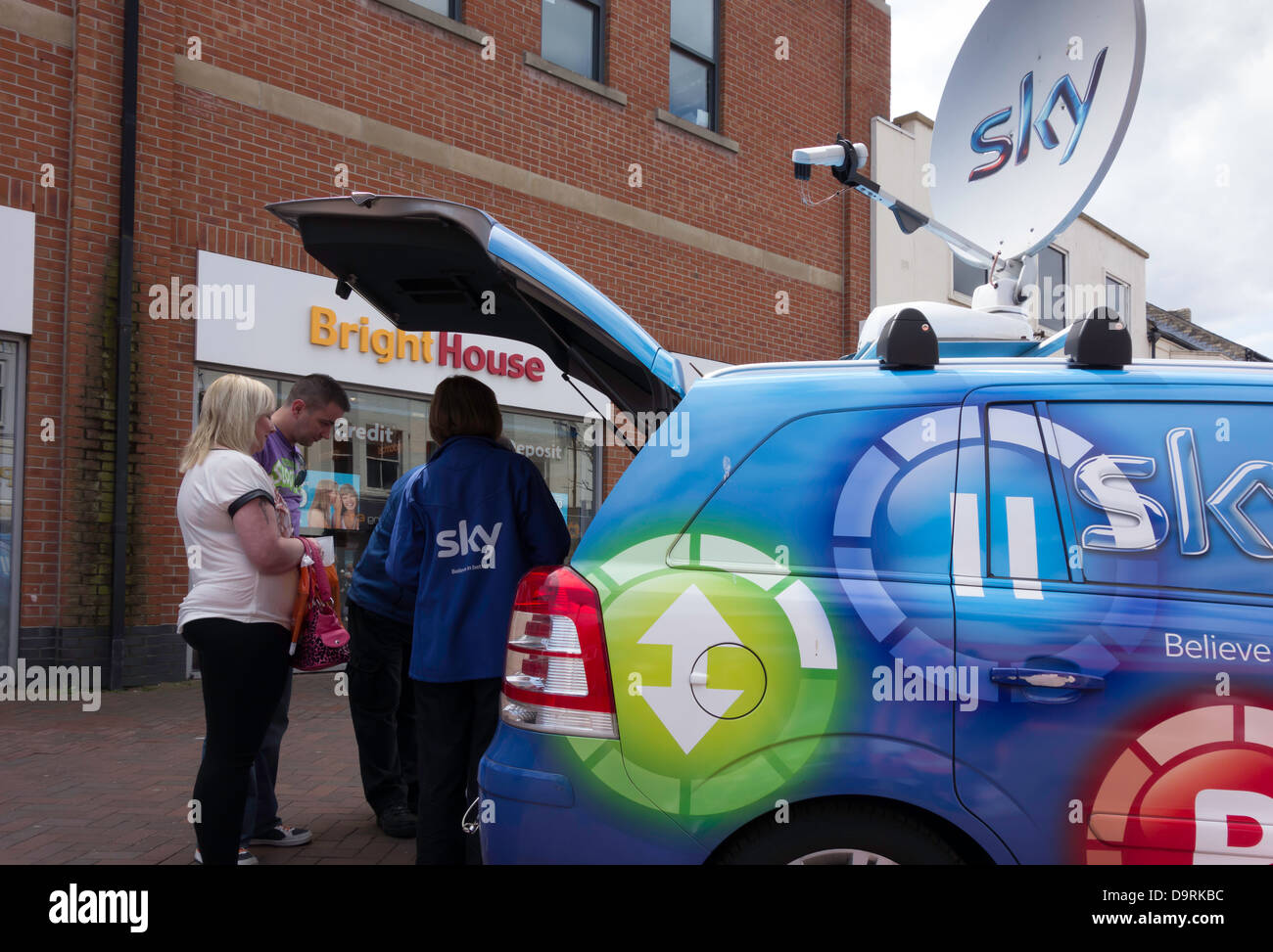 I rappresentanti di Sky Television la vendita di un servizio a un giovane in strada alta. Foto Stock