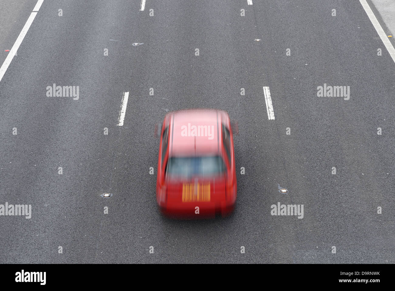 Red car guida nella corsia centrale Foto Stock