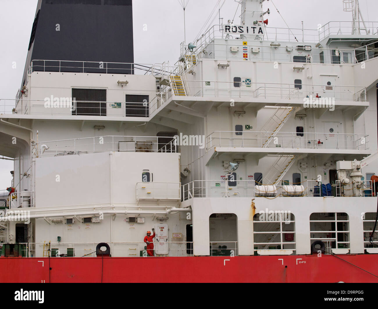 L'uomo sailor sventolare sul ponte di Rosita carrier nave nel porto di Rotterdam, Paesi Bassi Foto Stock
