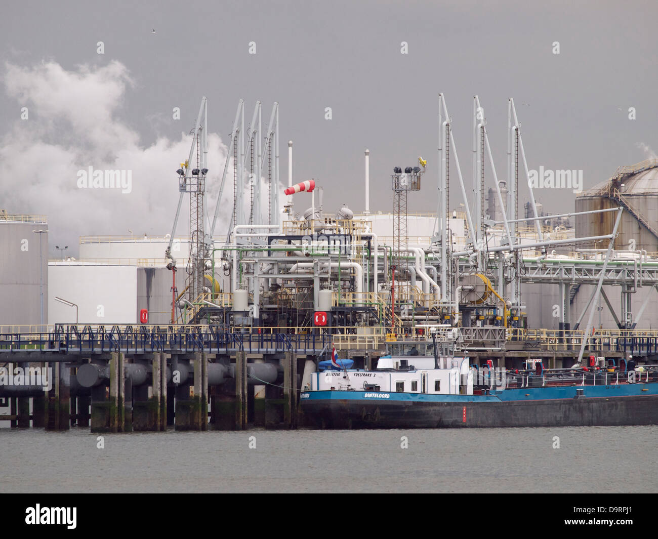 Impianto petrolchimico nel porto di Rotterdam con supporto combustibile chiatta lungo la banchina Foto Stock