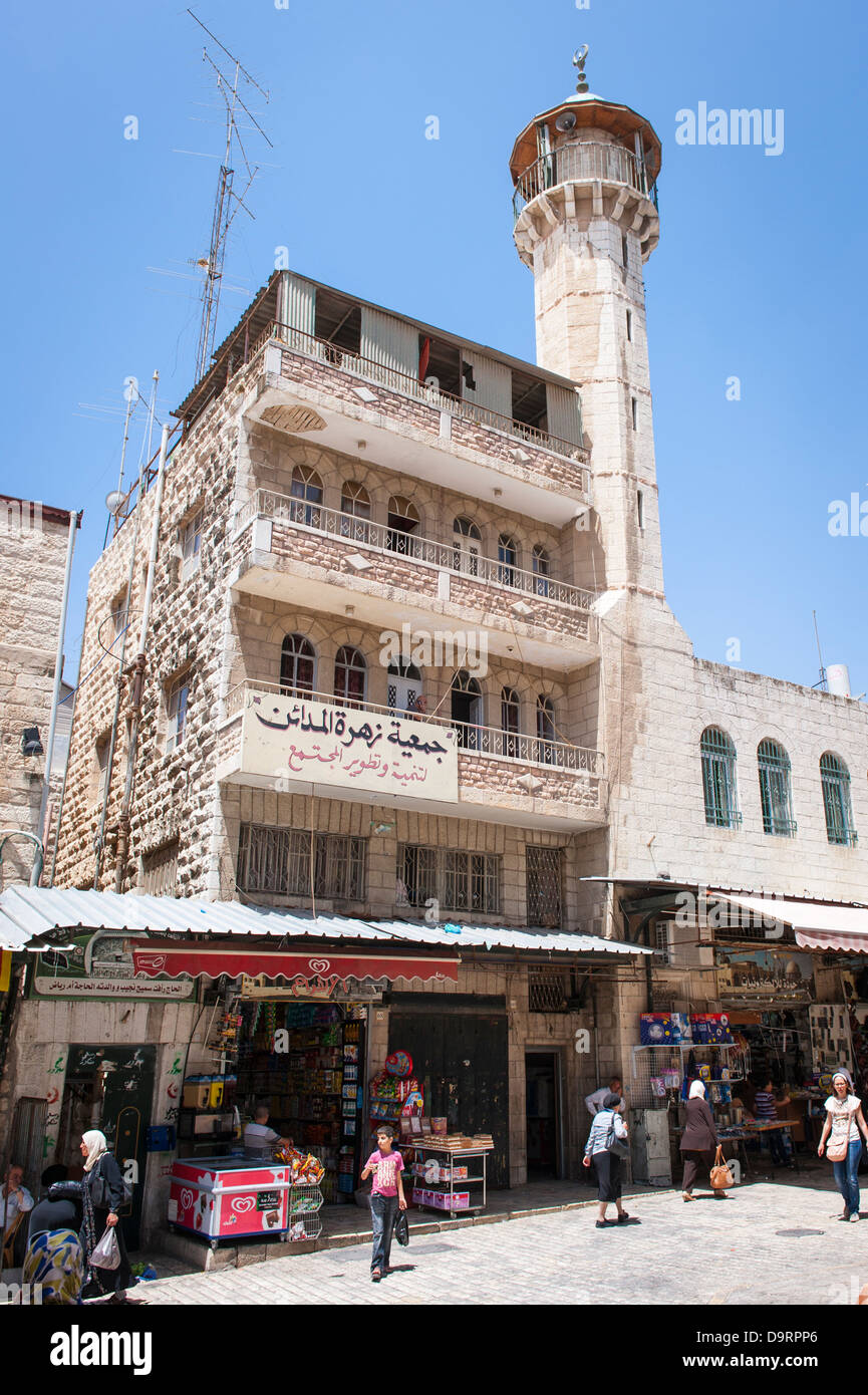 Israele Gerusalemme vecchia città araba musulmana trimestre Al Ahram Hotel Minaret caramella dolce drogheria drogheria prodotti elettrici shop store persone scene di strada Foto Stock