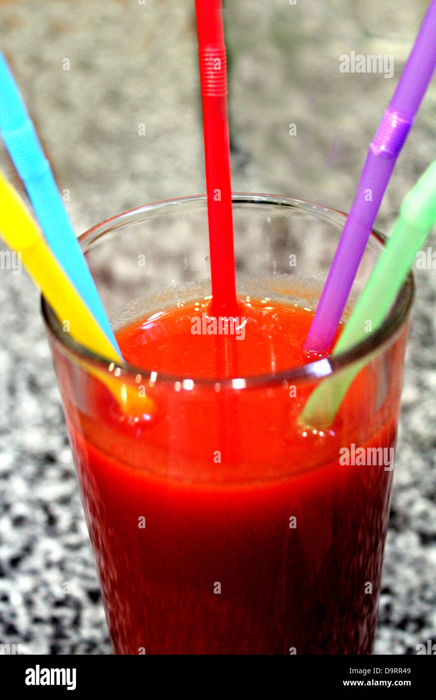 Immagine del bicchiere di succo di pomodoro con multi-tubuli colorati Foto Stock
