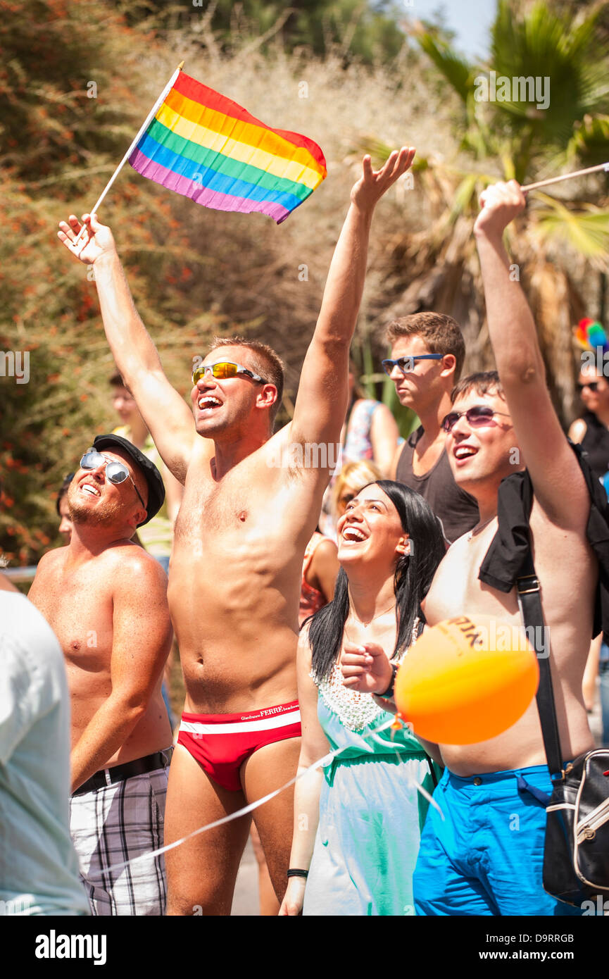 Israele , Tel Aviv Gay Pride alle celebrazioni del Giorno sfilata di  giovani ragazze e ragazzi onda per gli spettatori con Rainbow & bandiere  LGBT Foto stock - Alamy