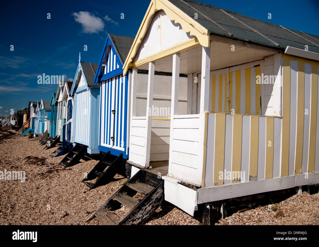 Lungomare viste che mostrano le cabine mare , sabbia, mare e cielo blu Foto Stock