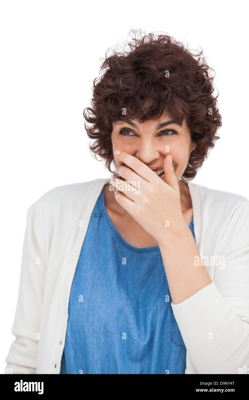 Donna sorridente con la mano sulla sua bocca Foto Stock