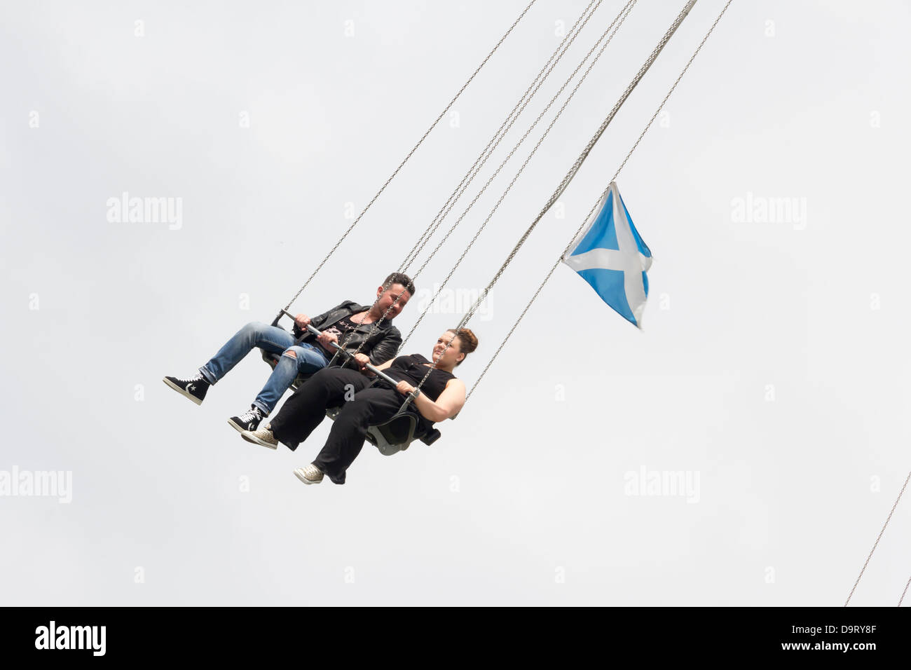 Due persone, un uomo e una donna, cavalcando la Starflyer ride in Piccadilly Gardens, Manchester. Foto Stock