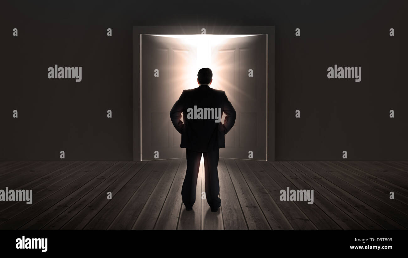 Imprenditore guarda porte con apertura ad una luce brillante Foto Stock