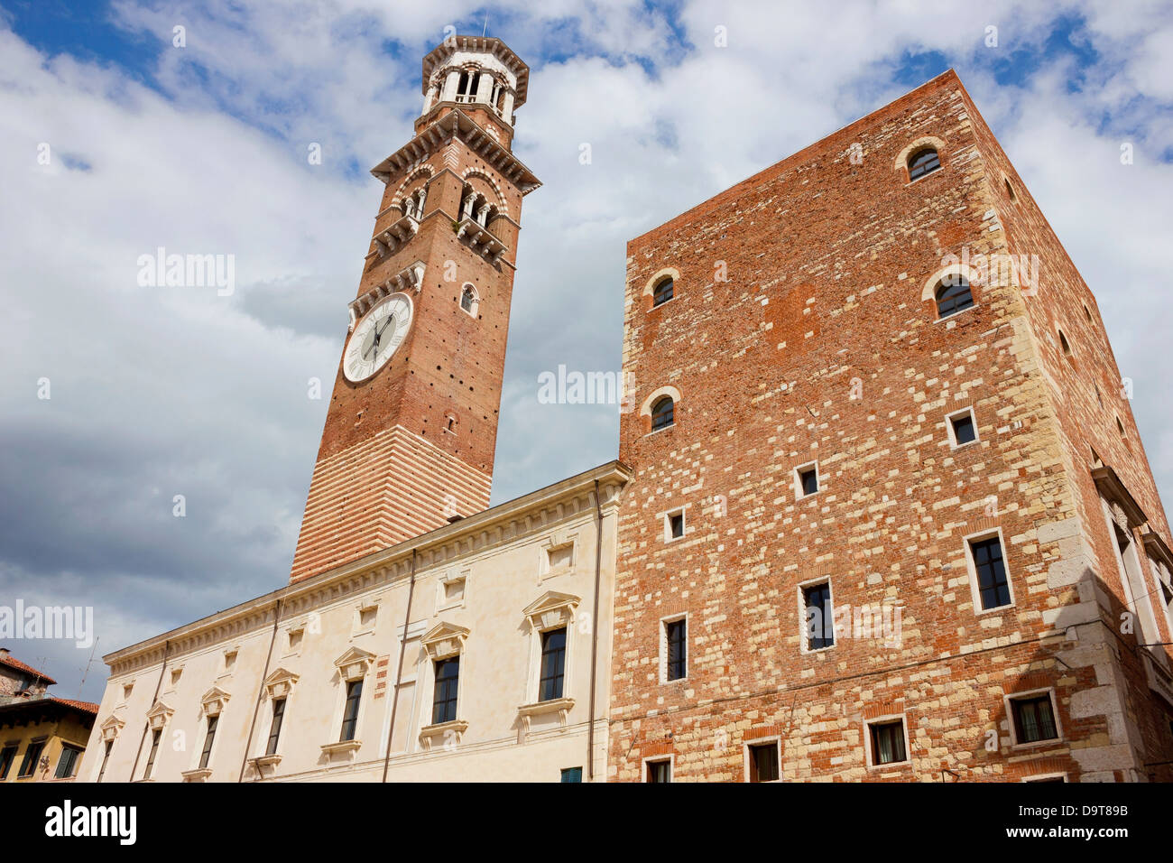 Torre dei Lamberti Facciata su piazza Erbe a Verona in una luminosa giornata di sole con alcune nuvole drammatico in background. Foto Stock