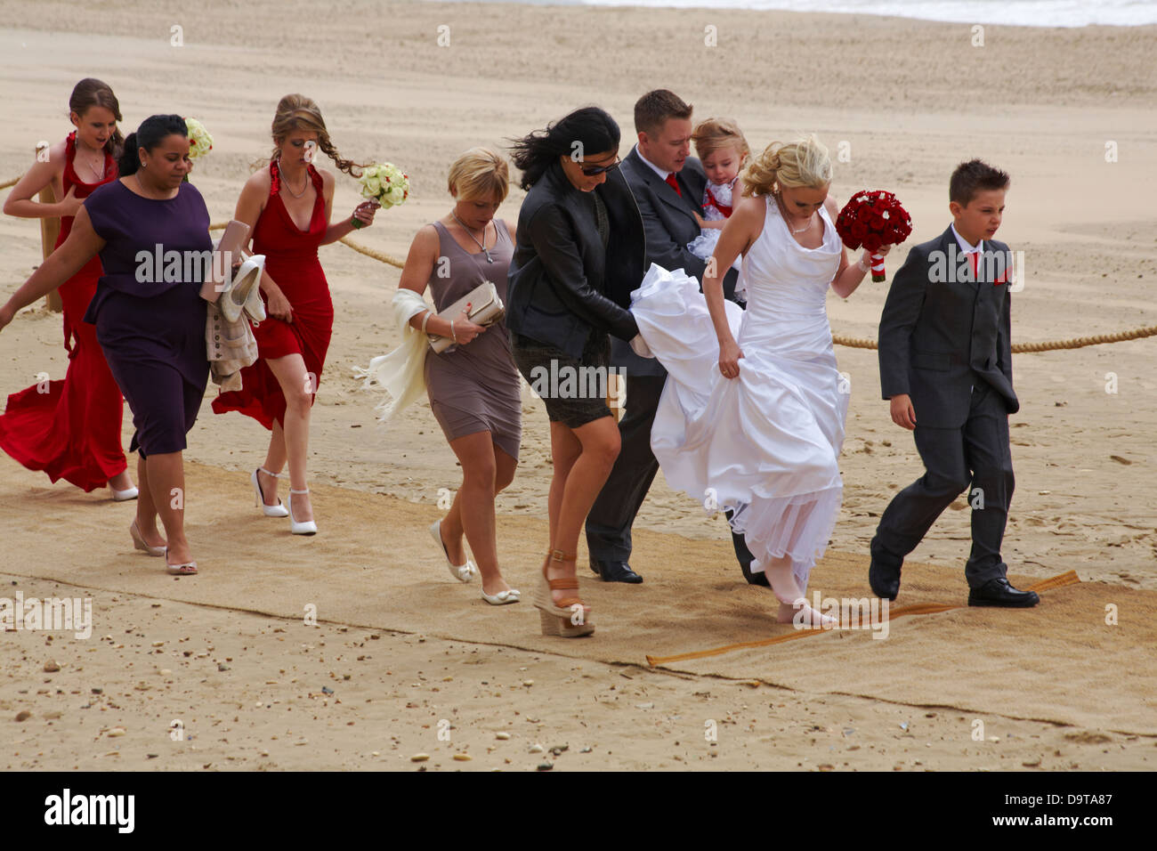 Festa nuziale, sposa e damigella arrivando alla cerimonia di nozze su Bournemouth Beach nel giugno Foto Stock