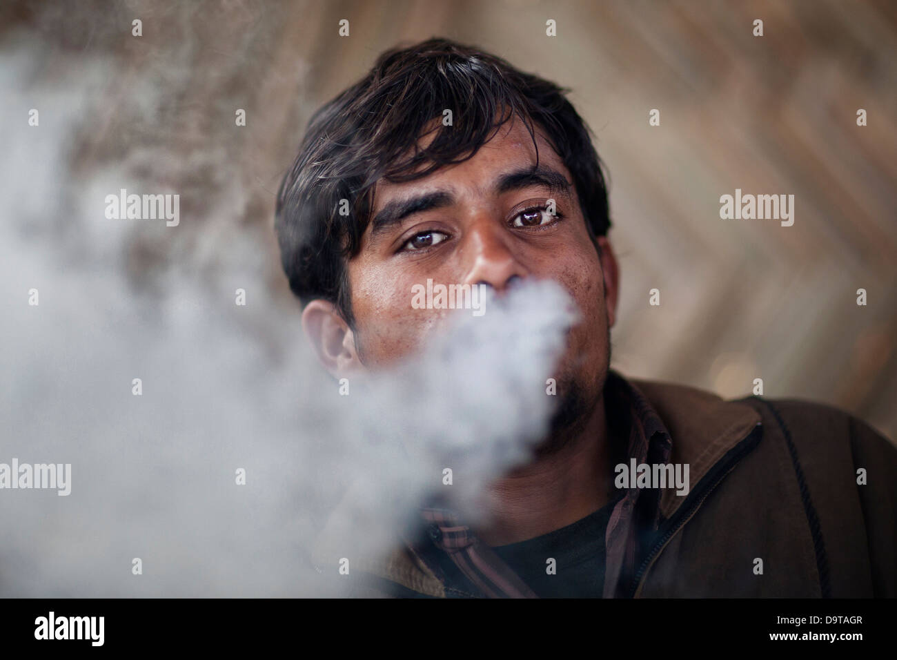 Ritratto di un abitante locale fumatori un tubo presso il Kumbh Mela 2013 in Allahabad, India Foto Stock