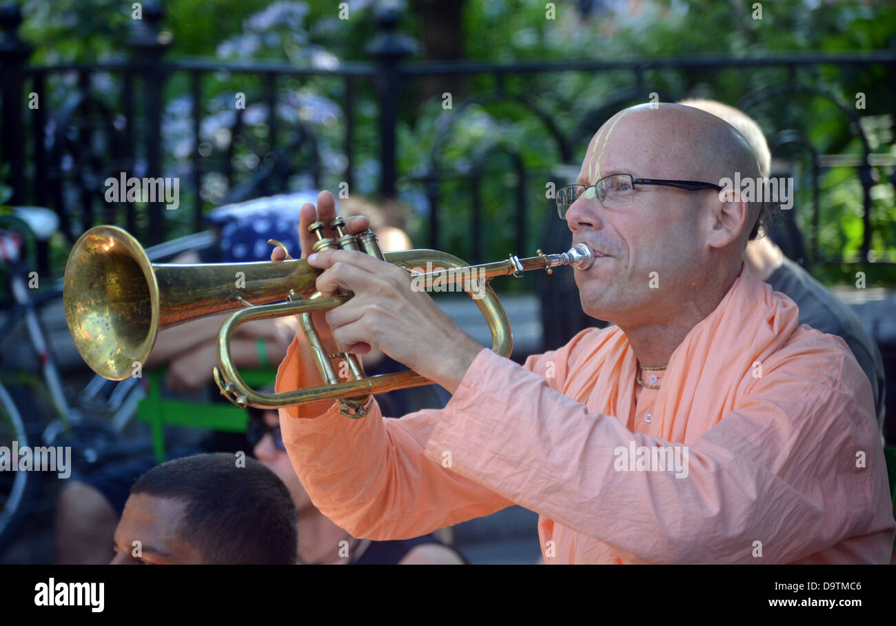 Persone di mezza età bald Hare Krishna street performer la riproduzione del Flicorno in Union Square Park di New York City Foto Stock