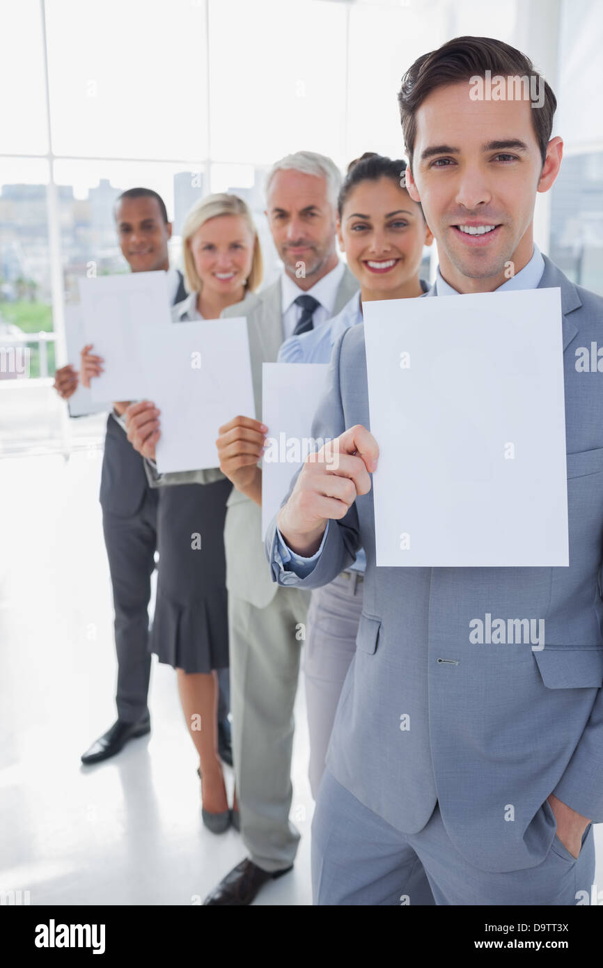 Il team di Business in una linea di contenimento delle pagine bianche Foto Stock