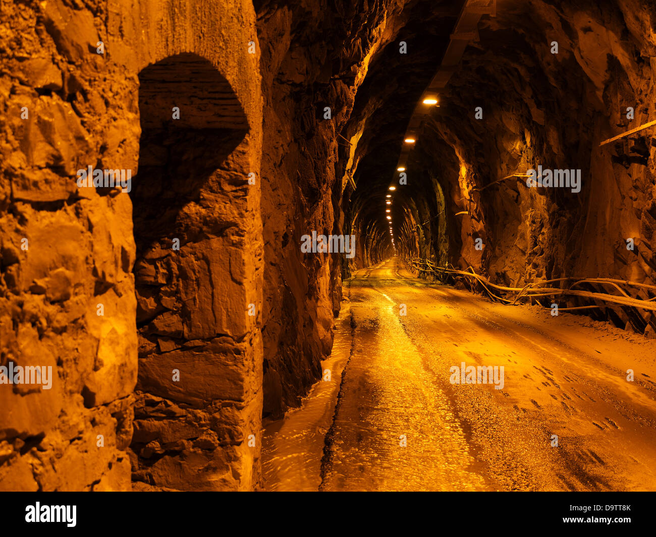 Ruvida strada scavata sotto la montagna - con auto Foto Stock