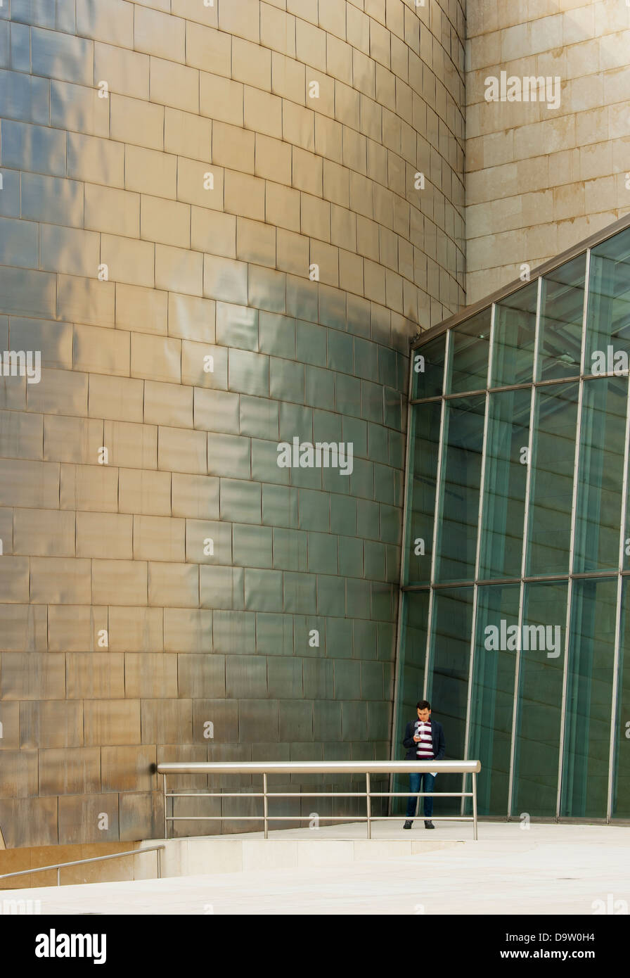 Uomo e cellulare, al di sotto del Museo Guggenheim, Bilbao, Spagna, Architetto : Frank Gehry Foto Stock