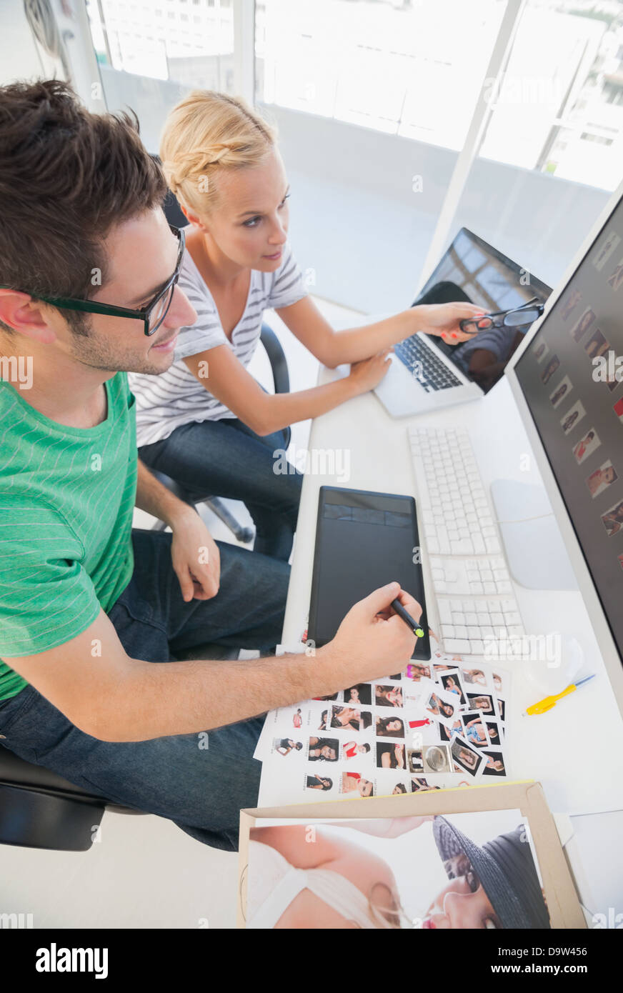 Foto di allegra gli editori che lavorano insieme su tavoletta grafica Foto Stock