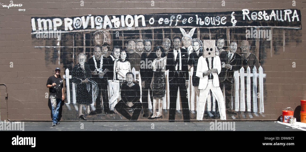 Los Angeles, California, USA. Il 26 giugno, 2013. WYLAND sorge accanto alla sua quasi completato il murale a Hollywood migliorare sulla Melrose Avenue a Los Angeles il Mercoledì, 26 giugno 2013. WYLAND dipinta 57 ben noto fumetto di più grandi dimensioni di vita sulle pareti che circondano l'ingresso al famoso comedy club. WYAND e il Wyland Foundation support la conservazione dell'acqua, proveniente insieme negli ultimi mesi con ''fumetti per la conservazione dell'acqua," allo scopo di raccogliere fondi per sostenere il Sindaco nazionale della sfida per la conservazione dell'acqua." Questa vista mostra solo una parete di quattro pareti Foto Stock