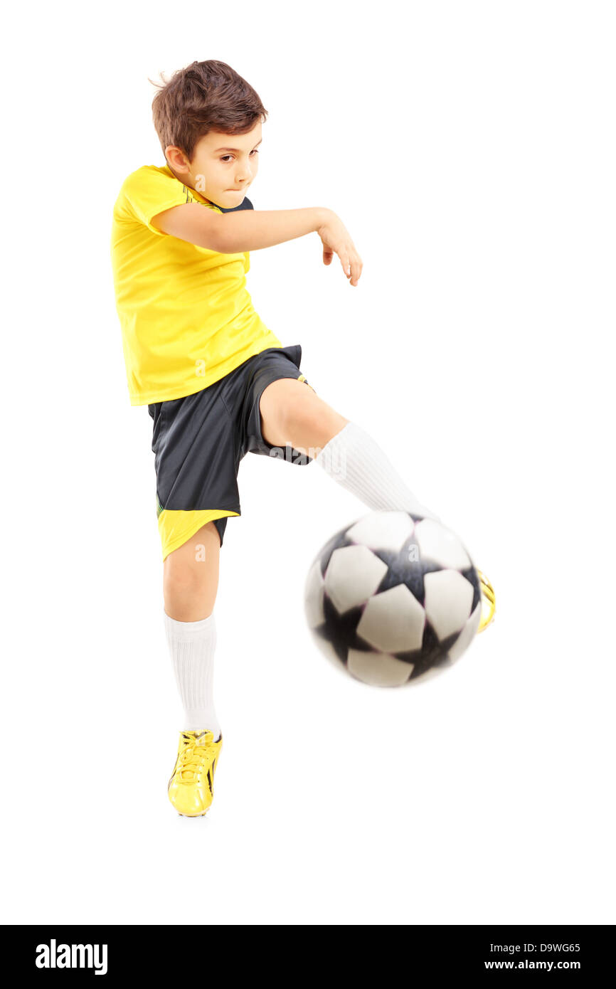 A piena lunghezza Ritratto di un bambino in abbigliamento sportivo la ripresa di un pallone da calcio Foto Stock